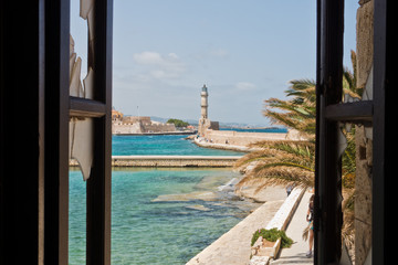 Fototapeta na wymiar A view of a lighthouse at the old Venetian harbor, city of Chania, Crete island, Greece