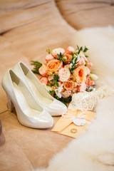 White shoes of the bride and a bouquet from fresh flowers with accessories of the bride
