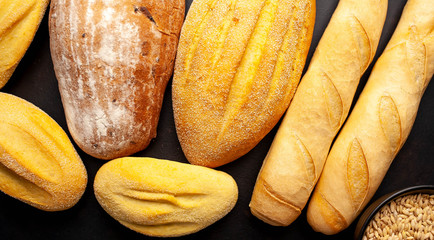 Various fresh bread and buns on a stone table. 