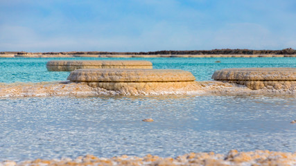 Salt formations in the Dead Sea blue and turquoise waters close up