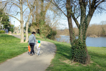 Mère et son fils se promenant dans un parc prés d'un fleuve