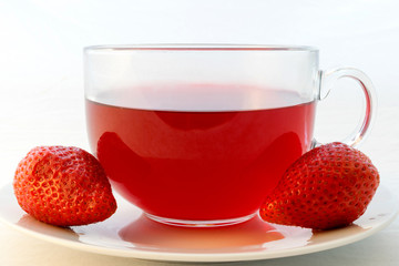 Glass cup of hot aromatic red tea with strawberries