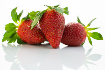 Group of red strawberries with green leaves