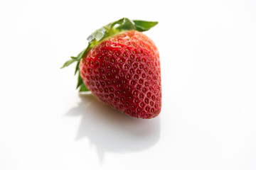 Red strawberry with green leaves isolated