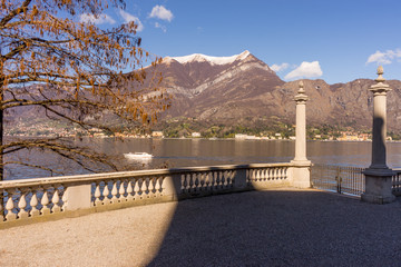 Italy, Bellagio, Lake Como, fence overlooking SCENIC VIEW OF SNOWCAPPED MOUNTAINS AGAINST BLUE SKY, Lombardy.