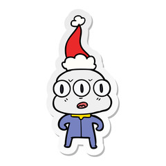 sticker cartoon of a three eyed alien wearing santa hat