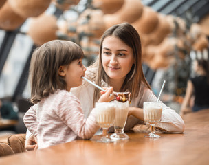Happy young women mother with children drinking a milkshake