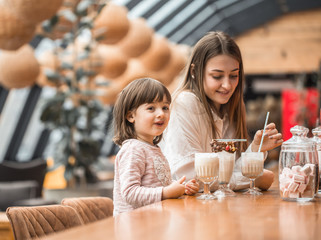 Happy young women mother with children drinking a milkshake