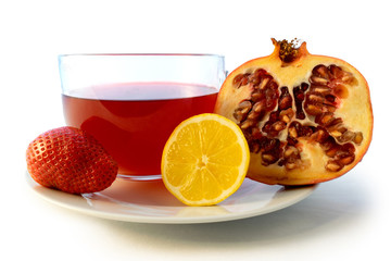 Glass cup of hot aromatic red tea with pomegranate, strawberry and lemon