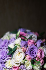 Wedding bouquet and rings illuminated by photo with light.