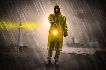 Fototapeta na wymiar Man at the coast coming in raincoat with glowing lantern concept 