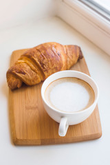 Traditional French breakfast of coffee and fresh croissant