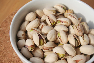 Pistachios in a bowl on wooden table 