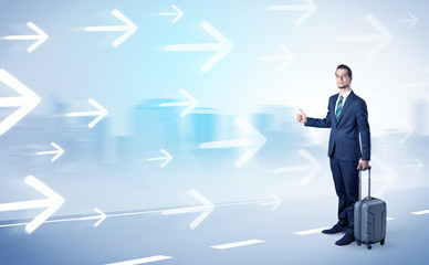 Young businessman hitchhiking near the city with arrows around concept