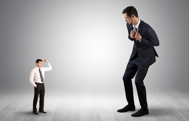 Big debutant young businessman scared of small strong businessman
