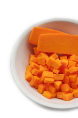 Fresh Butternut squash cut in pieces in a bowl isolated on white background