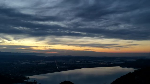 time-lapse over a lake with clouds moving fast over the lake.