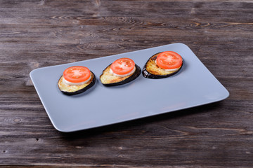 fried eggplant with sauce and tomato on a plate