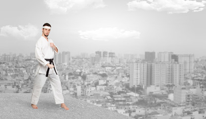 Young karate trainer doing karate tricks on the top of a metropolitan city
