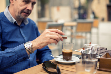 happy mature man sitting in the terraze outdoor and drinking  coffe for breakfast