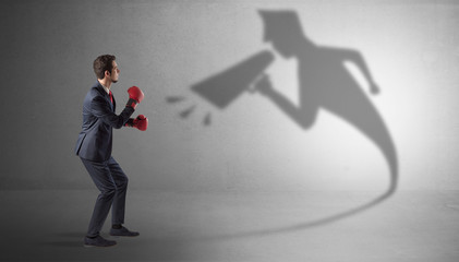 Businessman fighting with his bossy yelling shadow
