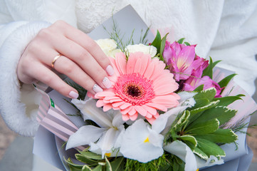 hand with a ring holds a bouquet of flowers