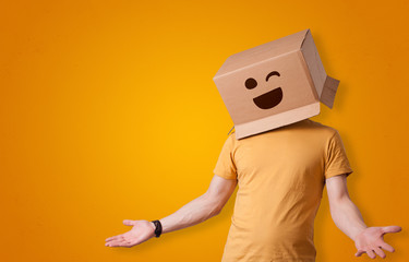 Funny man wearing cardboard box on his head with smiley face
