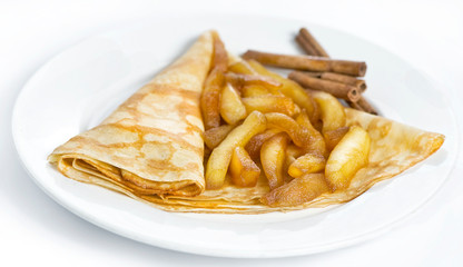 Thin delicious pancake with fired apple on white