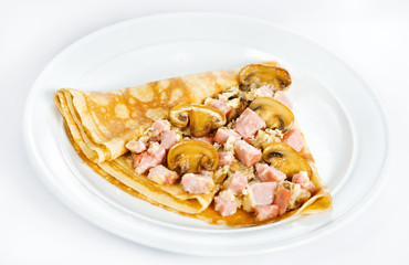 Thin delicious pancake with ham and mushrooms on white