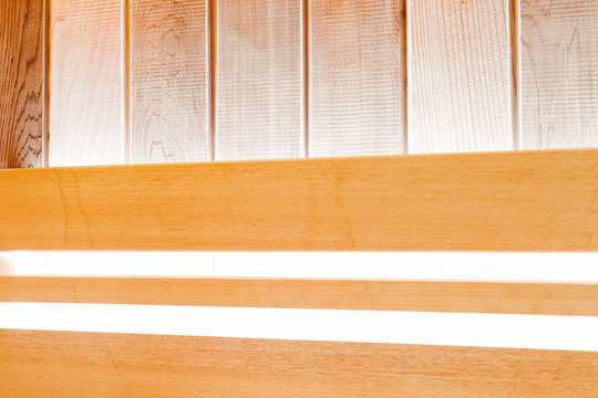 Wooden wall of traditional Finnish sauna with bright lighting. Background for design