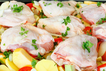 Delicious raw chicken with fresh vegetables, fruits and spices
