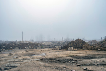 The remains of a large concrete building in the misty haze in the form of fragments of piles and...