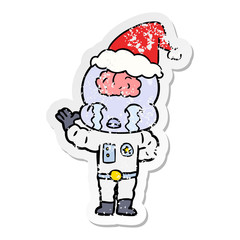 distressed sticker cartoon of a big brain alien crying wearing santa hat