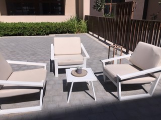 White and Beige Patio Furniture Placed in Backyard.
