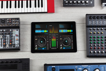 Mixing music on tablet with electronic music instruments concept

