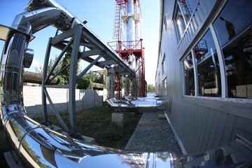 Wide-angle panoramic photo of the newest alternative fuel boiler room with pipes, towers and tanks, on a clear summer day, without people