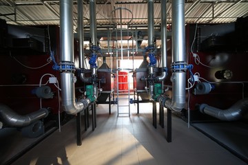 Wide-angle panoramic photo of the newest alternative fuel boiler room with pipes, towers and tanks, on a clear summer day, without people