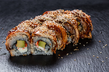 Philadelphia makizushi roll with extra unagi over slate plate background