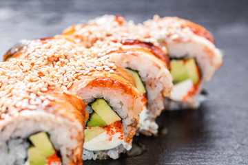 Close-up of unagi philadelphia roll arranged on slate plate