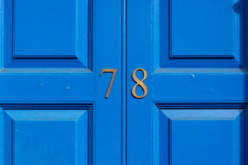 House number 78 on a blue painted wooden door