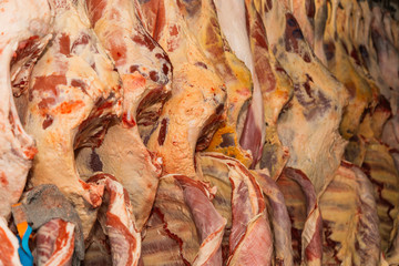 Refrigerated warehouse, hanging hooks of frozen lamb carcasses. Halal cut.