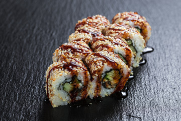 California with unagi seasoned with sauce over slate plate background