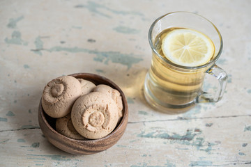 Fototapeta na wymiar Glass of herbal tea and cookies on a wooden table