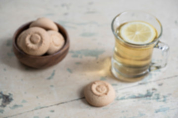 Fototapeta na wymiar Blurred background with a glass of herbal tea and cookies