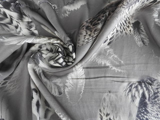 Smooth satin silk with grey feathers, texture.