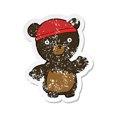 retro distressed sticker of a cartoon black bear wearing hat