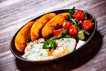 Fried egg, baked potatoes and vegetables