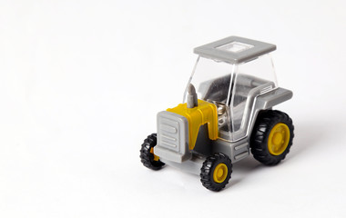yellow colored toy tractor on white background