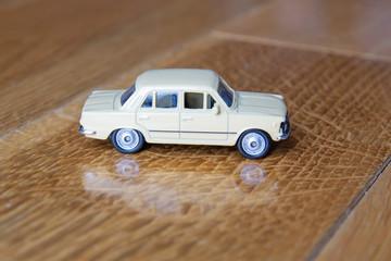 Vintage beige car toy on the wooden floor 