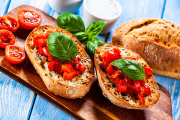 Bruschettas on cutting board on wooden background
